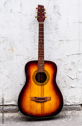 classical guitar of wood near a white wall © Yalana
