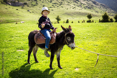 Boy rides a donkey photo