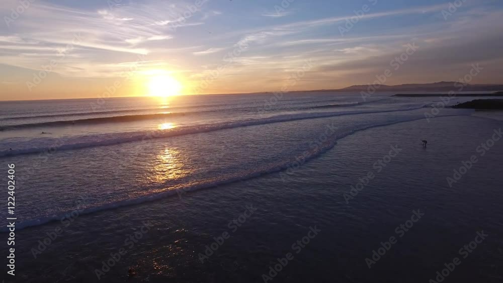 Surfers in the water during a beautiful sunset aerial view Surfers in the water during a beautiful sunset aerial view
