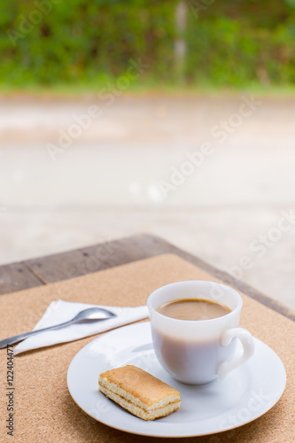 Cup of coffee with dessert on the table brown outside.
