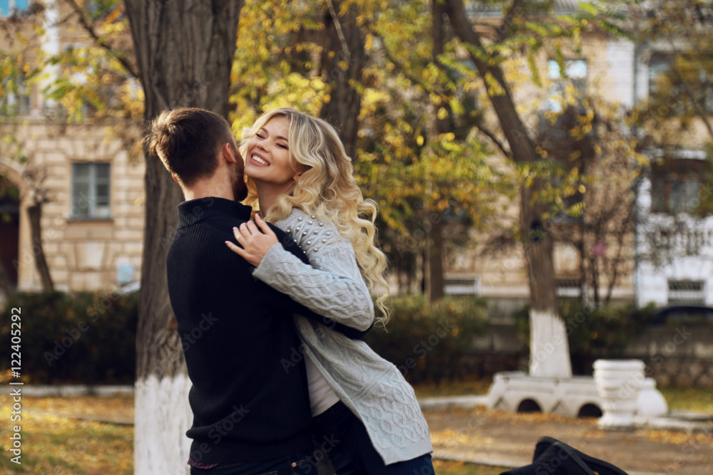 fashion outdoor photo of beautiful tender couple, wearing cozy clothes, walking by autumn park 