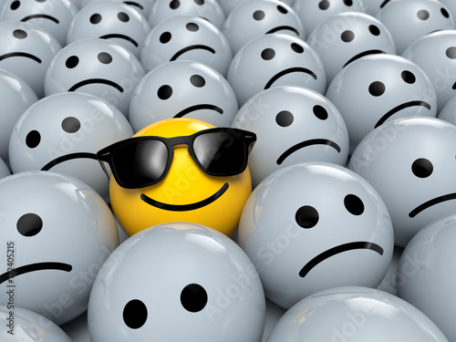Happy Smiley Emoticon mit Sonnenbrillen zwischen traurigen Emoticons 