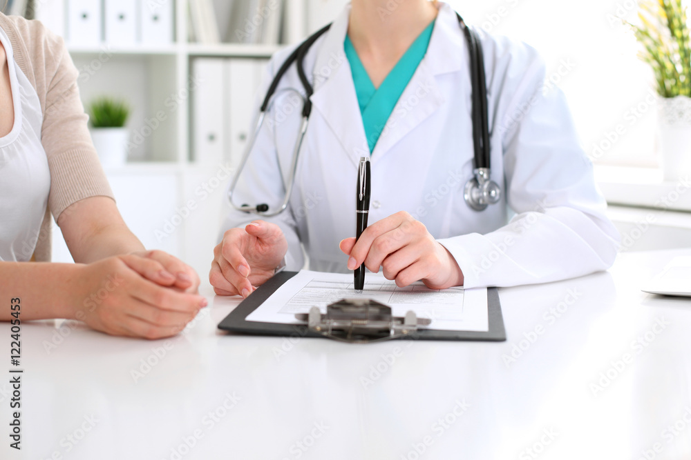 Doctor and patient are discussing something, just hands at the table Doctor and patient are discussing something, just hands at the table