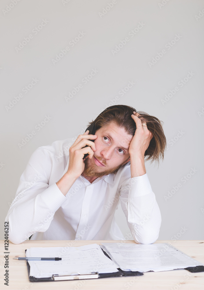 portrait of frustrated man working on laptop, talking on phone and getting problems at work portrait of frustrated man working on laptop, talking on phone and getting problems at work