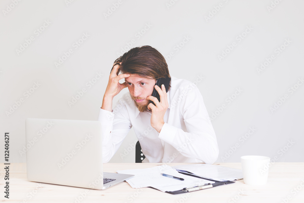 portrait of frustrated man working on laptop, talking on phone and getting problems at work portrait of frustrated man working on laptop, talking on phone and getting problems at work