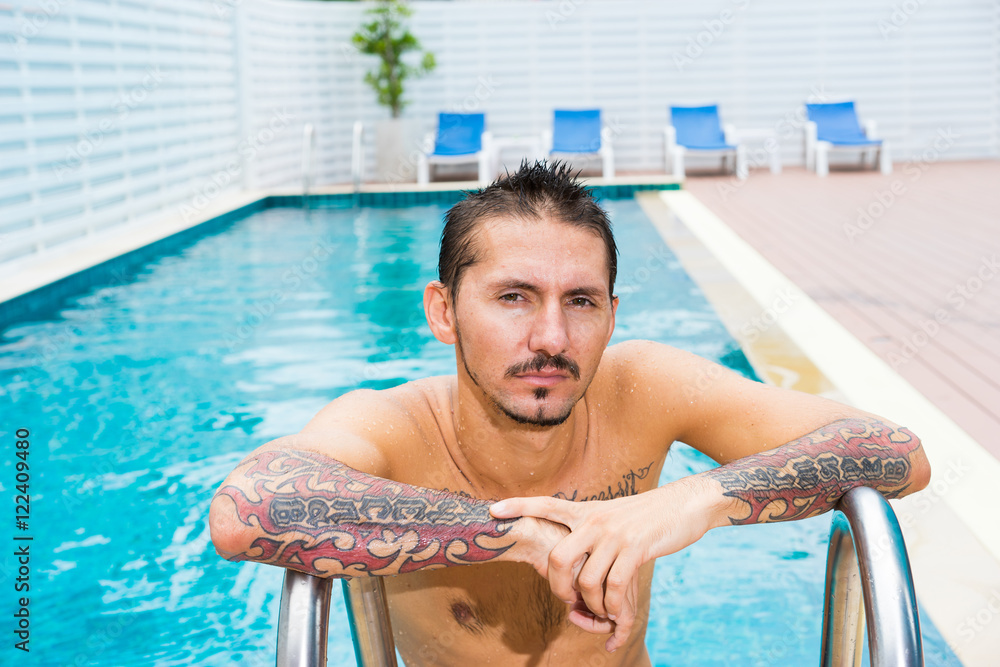 Portrait of man wirh tattoo in swimming pool. Stock Photo Adobe Stock