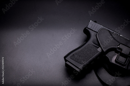 pistol in a holster in black background photo