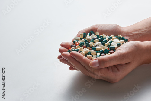 woman's hands holding a lot of pills