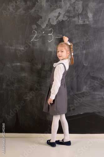 Fotografie Student writes with chalk on a blackboard