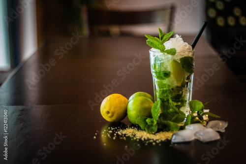 Caipirinha cocktail with fresh mint and crushed ice on wodden ta