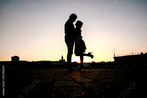 Принти на полотні Couple kissing outdoors - Lovers on a romantic date at sunset,girls stands on ti