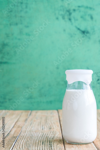 milk on a wooden table on Green background