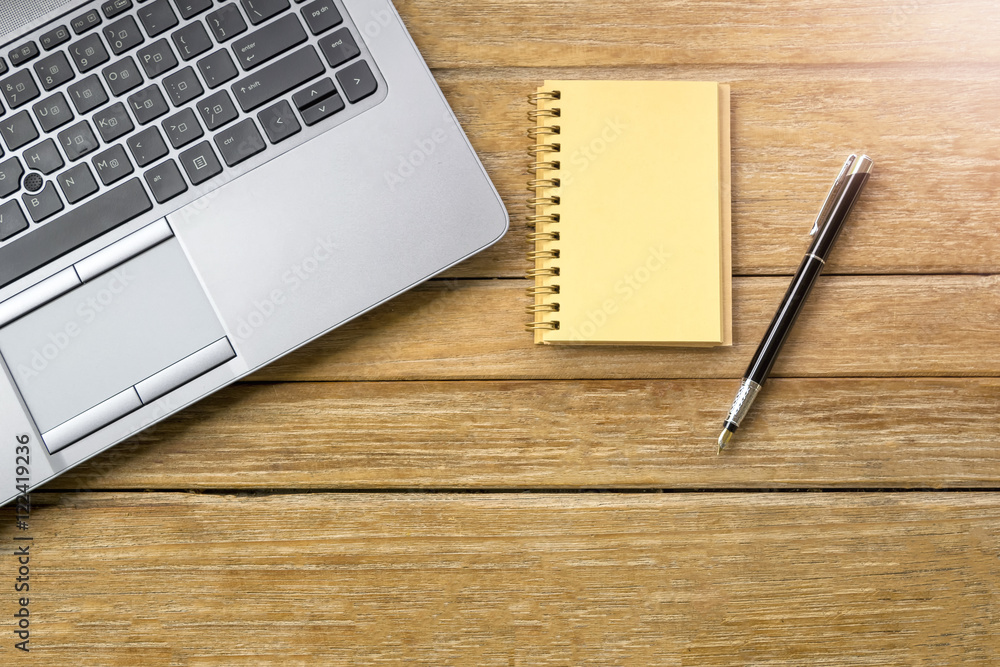 Business Creativity - Pen on the empty notebook and laptop on wooden table. Business Creativity - Pen on the empty notebook and laptop on wooden table.