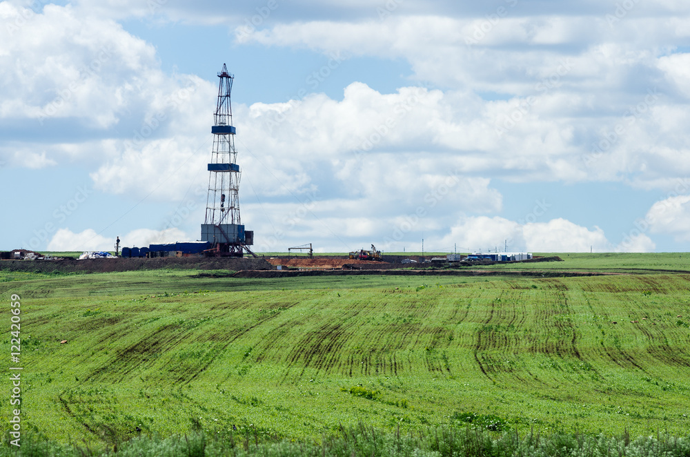 Oil rig in the middle of the field. Spring