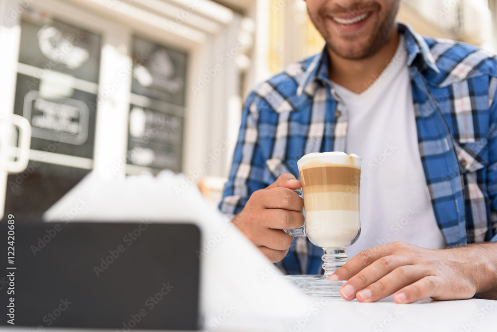Handsome man relaxing with cup of latte Handsome man relaxing with cup of latte