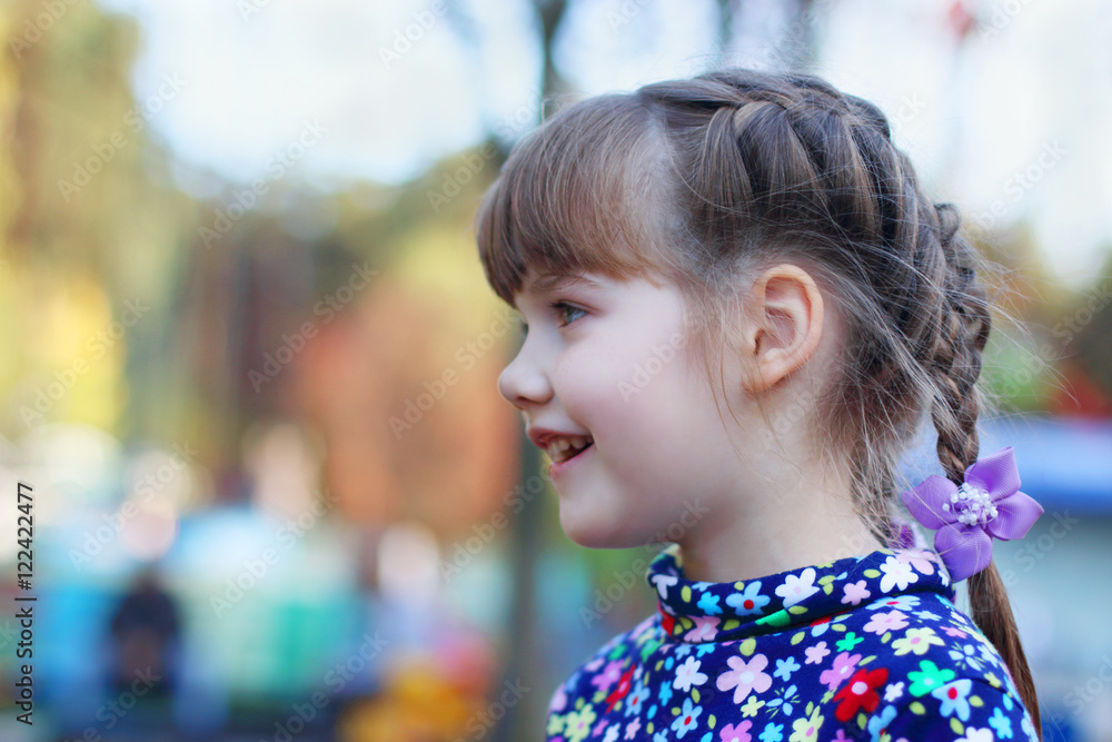 Happy little cute girl smiles and looks away outdoor, shallow do Happy little cute girl smiles and looks away outdoor, shallow do