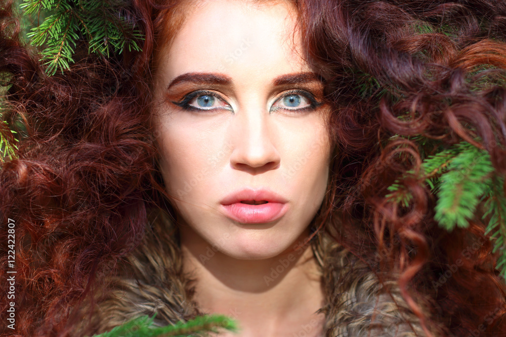 Young woman poses among fir branches in forest, shallow dof Young woman poses among fir branches in forest, shallow dof