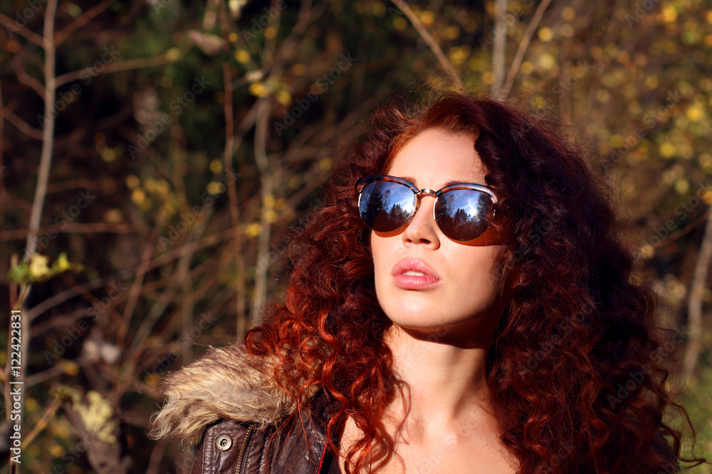 Pretty young woman in sunglasses at sunny day in autumn forest Pretty young woman in sunglasses at sunny day in autumn forest