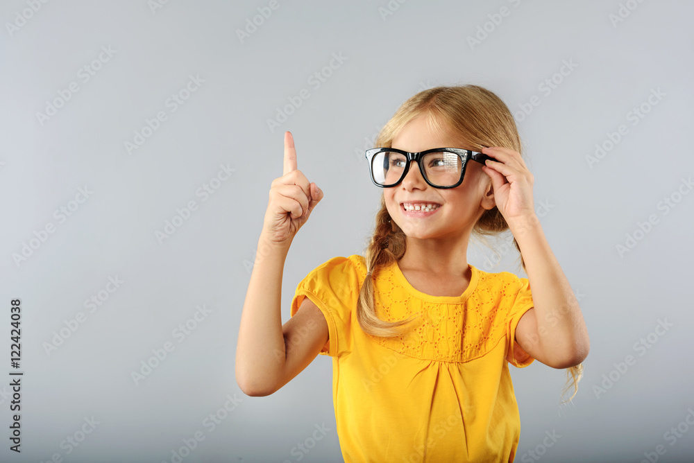girl pointing upwards with her index finger girl pointing upwards with her index finger