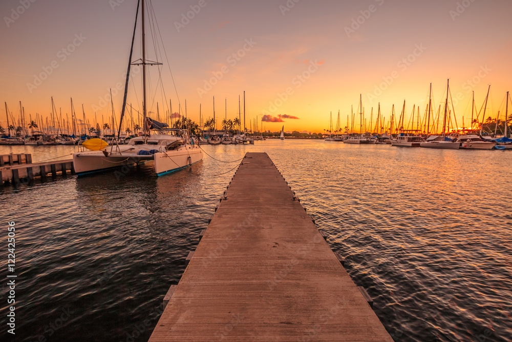 Wooden jetty in Ala Wai Harbor at twilight. Ala Wai Harbor is the largest small-boat and yacht harbor in Hawaii, situated between Waikiki and downtown Honolulu in Oahu Island, Hawaii, United States.