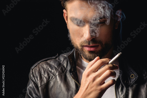 Attractive male smoker thinking with cigarette