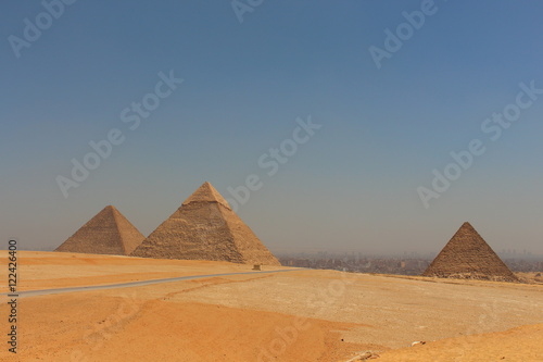 Main view of Giza pyramids with Cairo city in background.