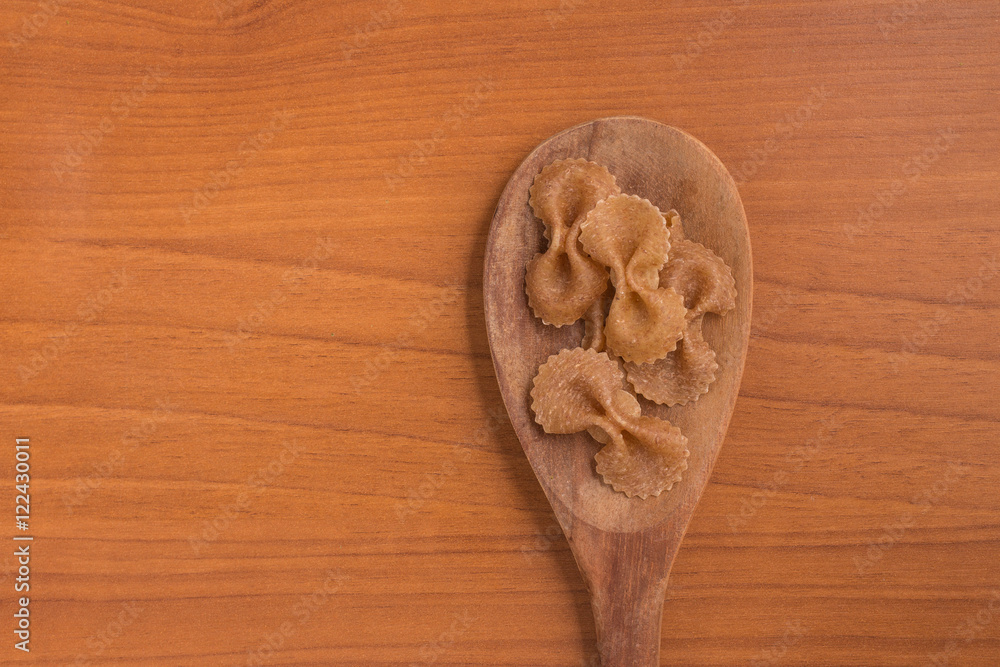 Wholegrain Farfalle into a spoon. wholemeal. Integral. Wholegrain Farfalle into a spoon. wholemeal. Integral.