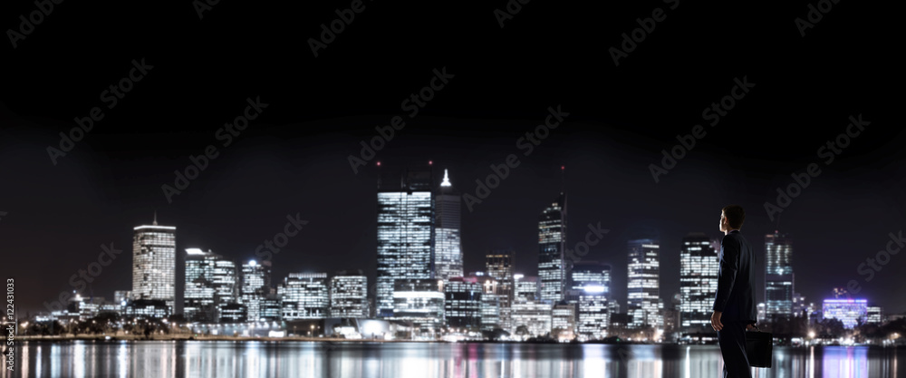 Businessman viewing night glowing city