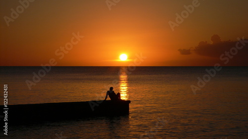 Lonely man relaxing in front of an amazing sunset in "Maria la gorda" beach, Cuba.