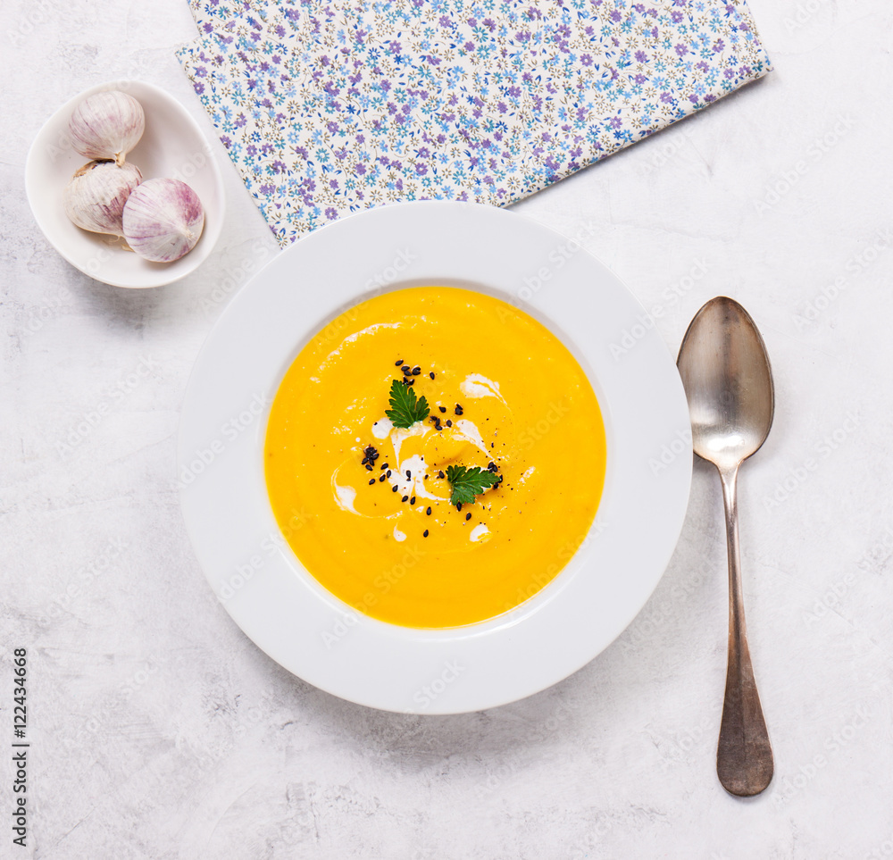 Pumpkin creamy soup in a white plate, top view Pumpkin creamy soup in a white plate, top view