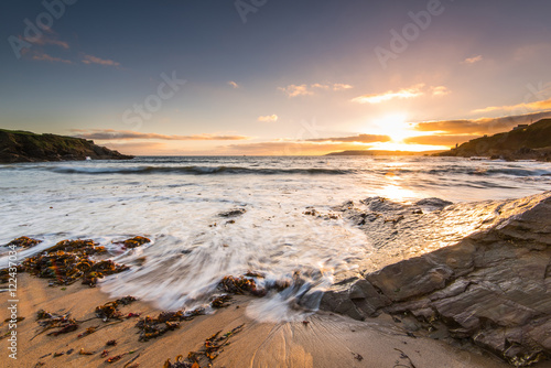 Epic sunset at rocky and sandy beach