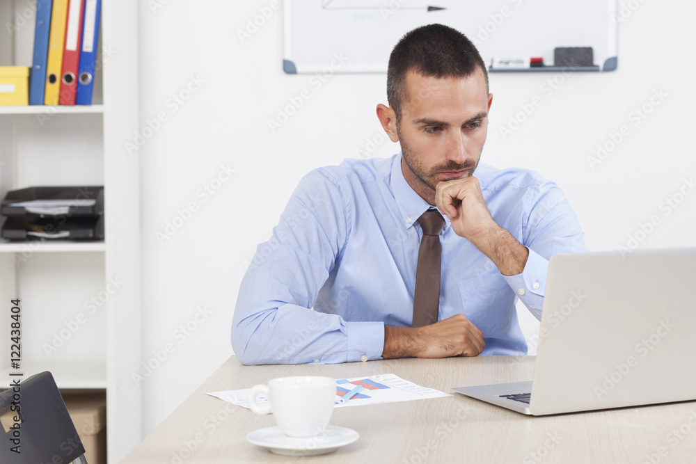 Stressed businessman working at his desk in his office Stressed businessman working at his desk in his office