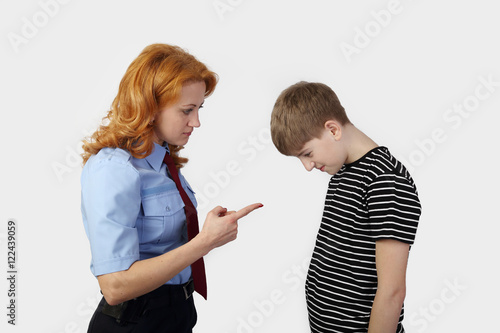 Foto Woman police officer chastises teenage boy on gray background