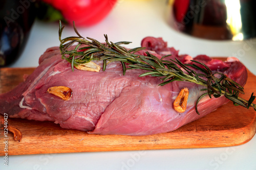 Beef filets - fresh red meat on wooden kitchen board with roasted rosemary and garlic slices. photo