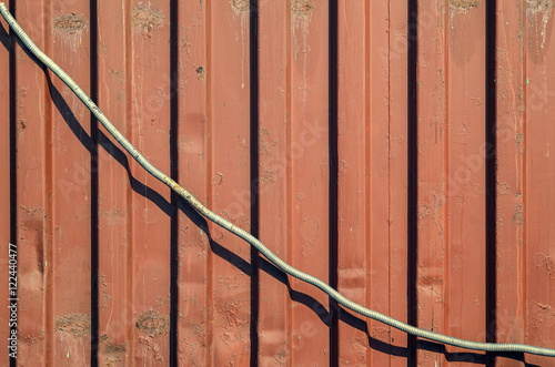 Metallic rusty stripe wall texture with a sagging cable. Graph of inverse proportionality concept