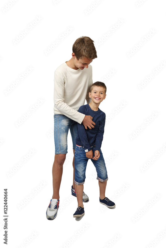 Happy teenage boy plays with his joyful little brother isolated on white background Happy teenage boy plays with his joyful little brother isolated on white background
