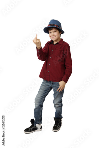 Teenage boy in blue hat, red shirt, jeans and sneakers shows indecent gesture full height isolated on white background