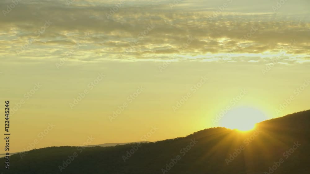 Brilliant summit sunrise above mountains and moving clouds, red sun disk time lapse in HDR Brilliant summit sunrise above mountains and moving clouds, red sun disk time lapse in HDR