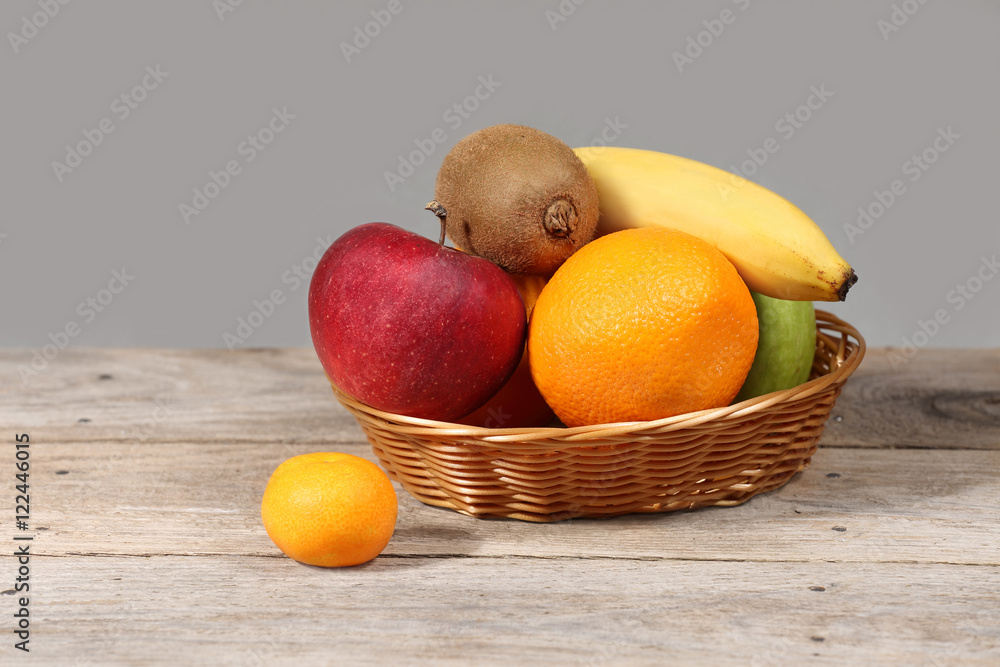 Set of different exotic tropical fruits in basket on wooden table Set of different exotic tropical fruits in basket on wooden table
