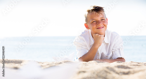 Boy lying on beach on sunny weather