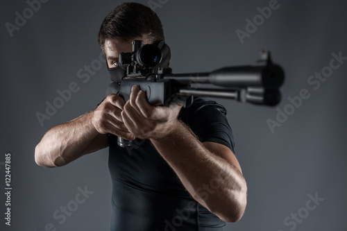 Close-ups of man with sniper rifle aiming isolated
