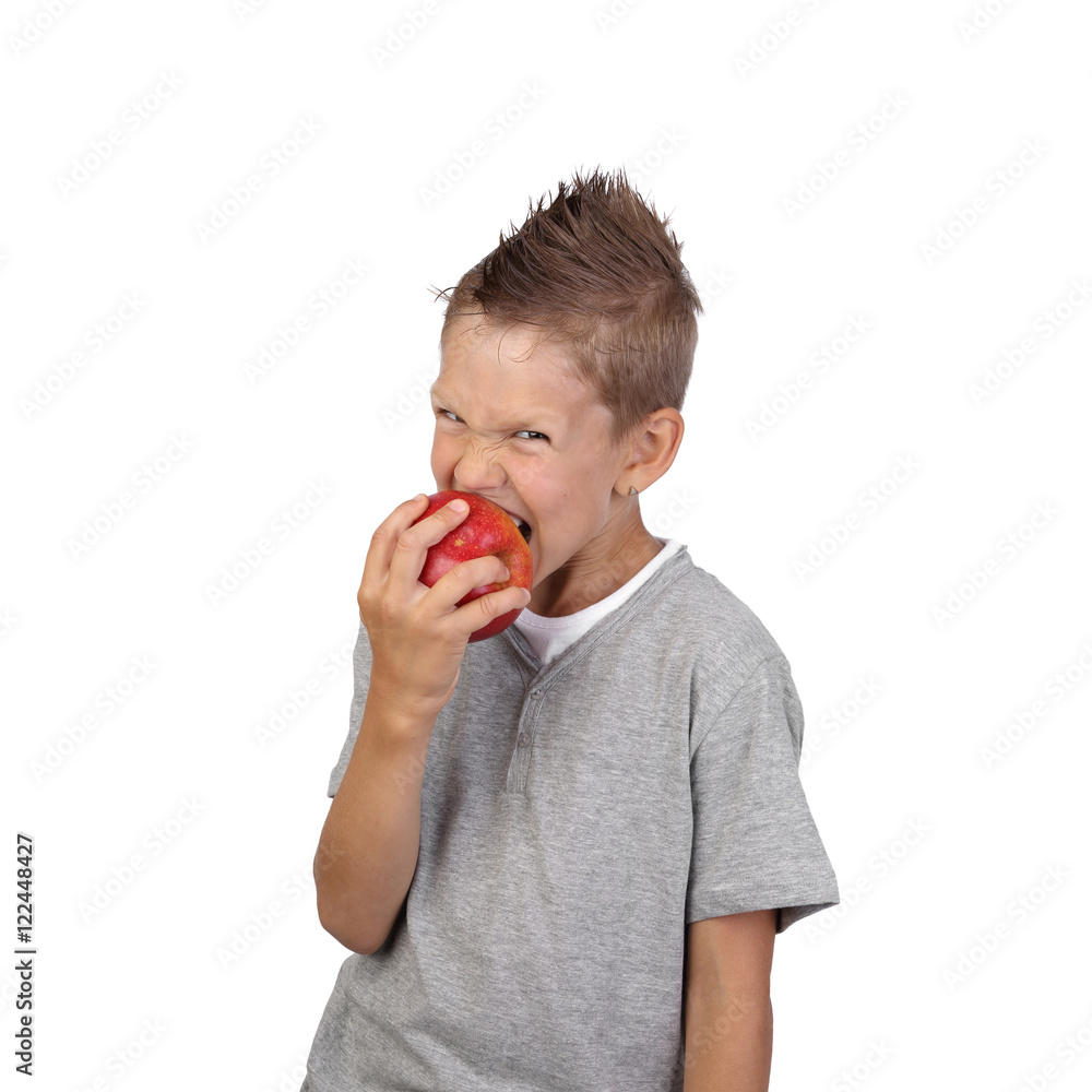 Joyful teenage boy aggressive bites off a big red apple in hand isolated on white background is square Joyful teenage boy aggressive bites off a big red apple in hand isolated on white background is square