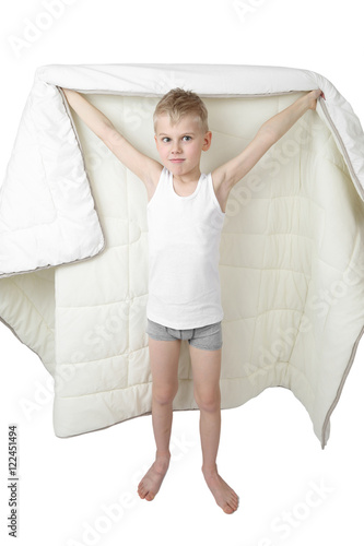 Cute little boy stands going to hide under blanket isolated on white background