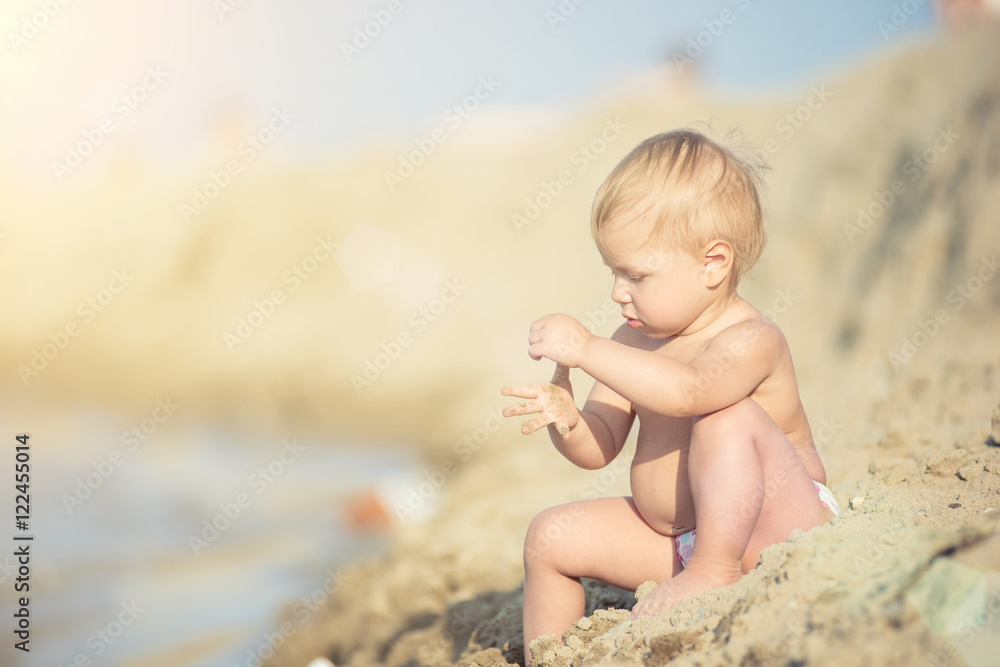 Baby playing with toys on the sandy beach near the sea. Cute little kid in sand on tropical beach. Ocean coast. Baby playing with toys on the sandy beach near the sea. Cute little kid in sand on tropical beach. Ocean coast.