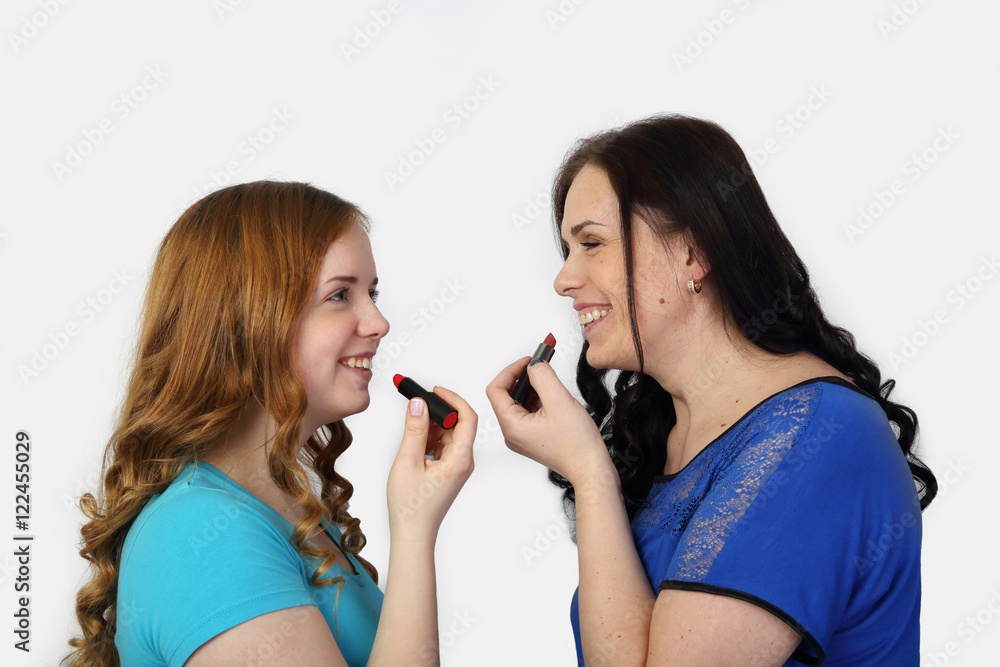 Adult woman and young redhead girl face to face smile with lipstick on gray background - Mother and daughter make up Adult woman and young redhead girl face to face smile with lipstick on gray background - Mother and daughter make up