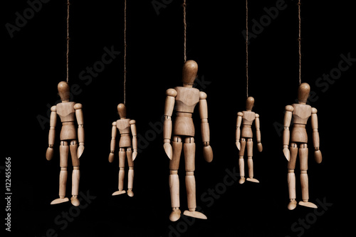 Low key, group of wooden marionettes puppet hangman by rope, on black background photo