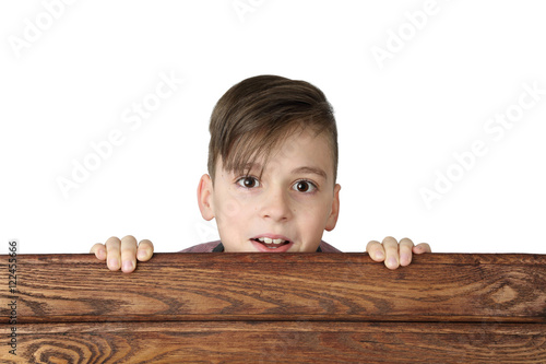 Cute handsome boy look over wooden fence isolated on white background