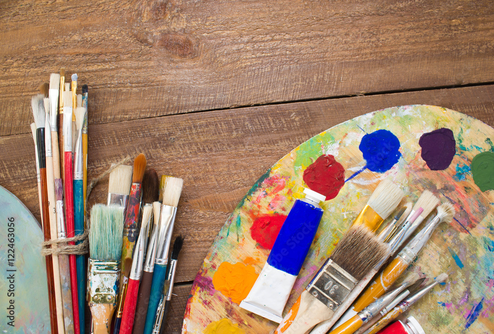 Obraz premium Paints, brushes and palette on the colorful background. The workplace of the artist. Banner for school