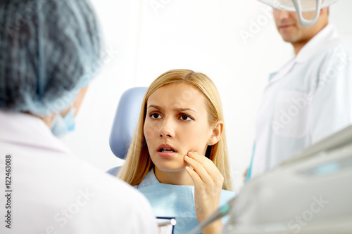A young woman at dentist office talking to the doctor
