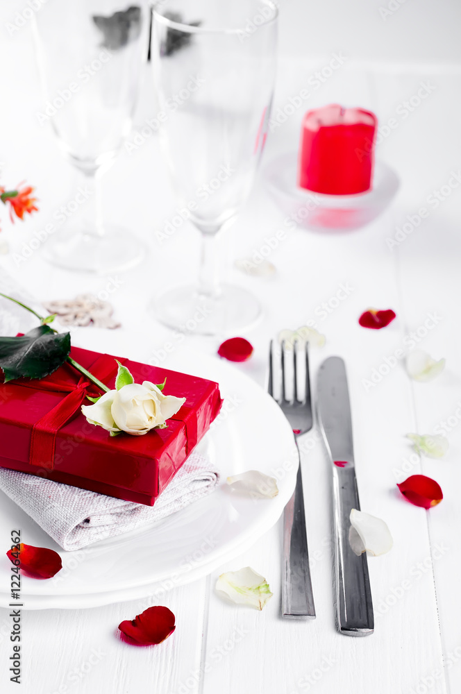Elegant holiday table setting with red ribbon gift Elegant holiday table setting with red ribbon gift